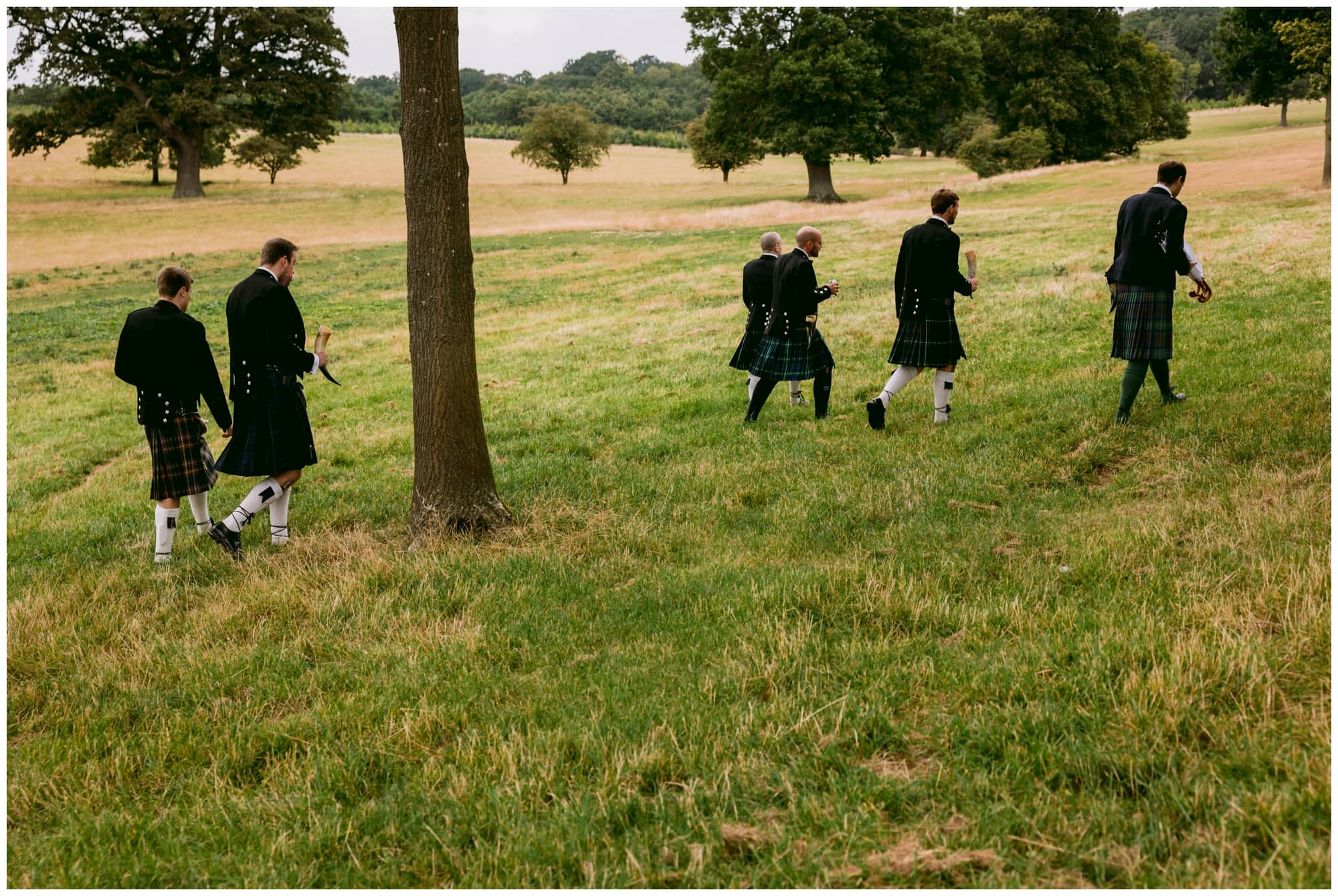 groomsmen walking across the fields at wilderness reserve.